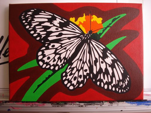 A black and white butterfly perched on green leaves against a red background.