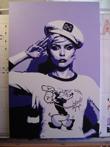 A woman in a sailor hat salutes while wearing a Popeye-themed T-shirt, in purple tones.