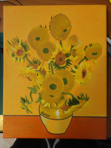 Bright yellow sunflowers in a vase against an orange background.