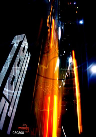 Abstract urban scene featuring blurred lights and tall buildings at night.